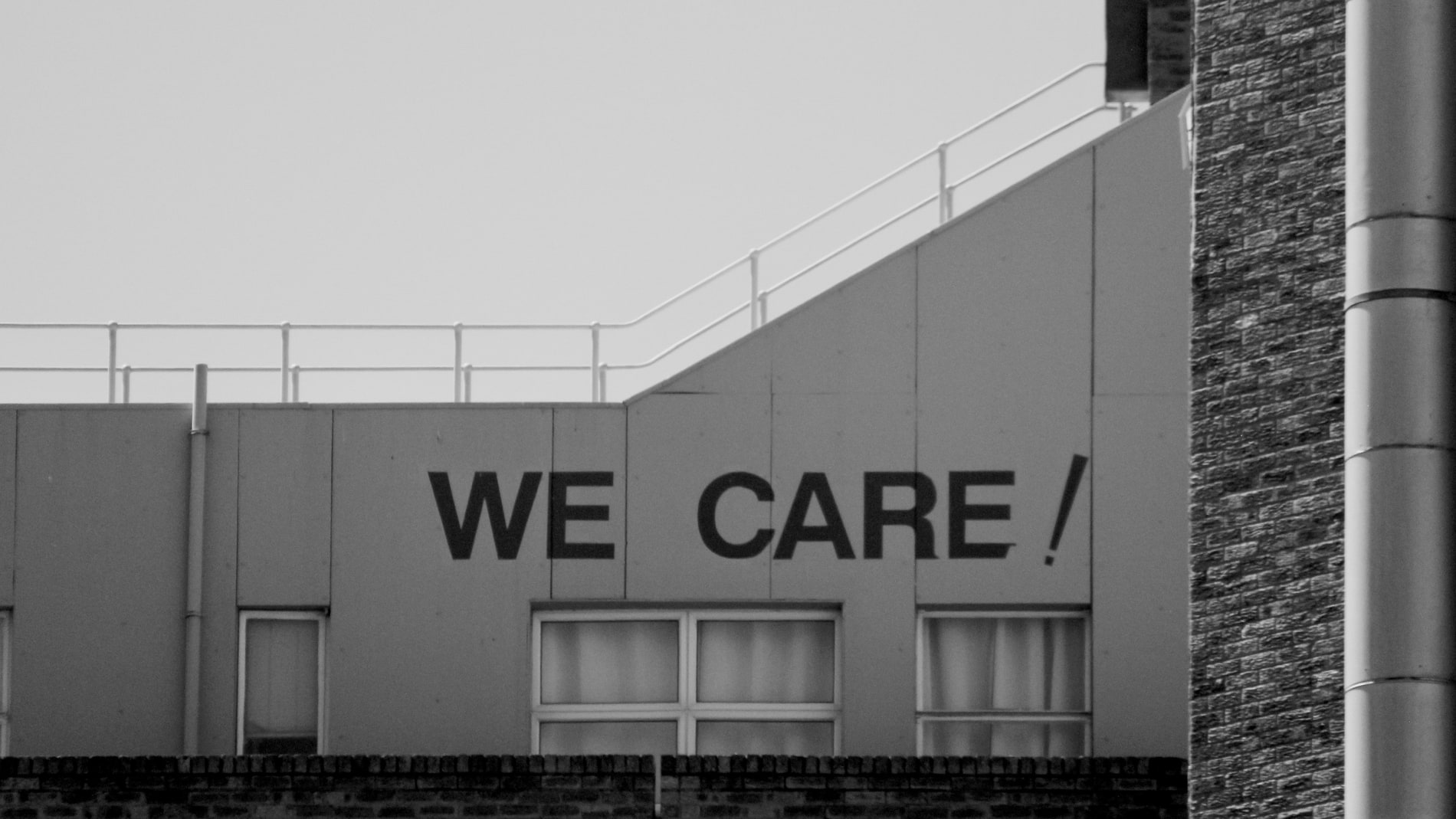The words we care painted large across the upper wall of a building