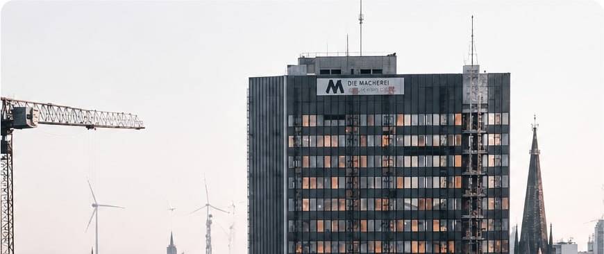 A city skyline with a tower crane beside a glass office building