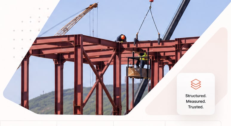 Steel erection: a crane lifting a beam onto a red steel frame